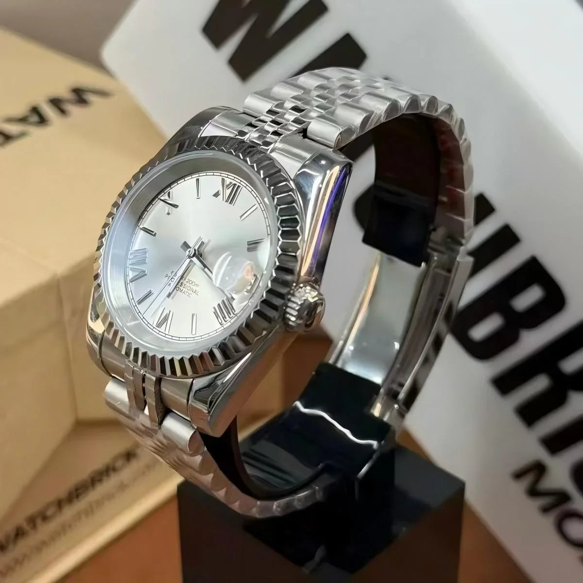 Silver Seiko mod watch with Roman numerals, fluted bezel, and stainless steel bracelet on display.