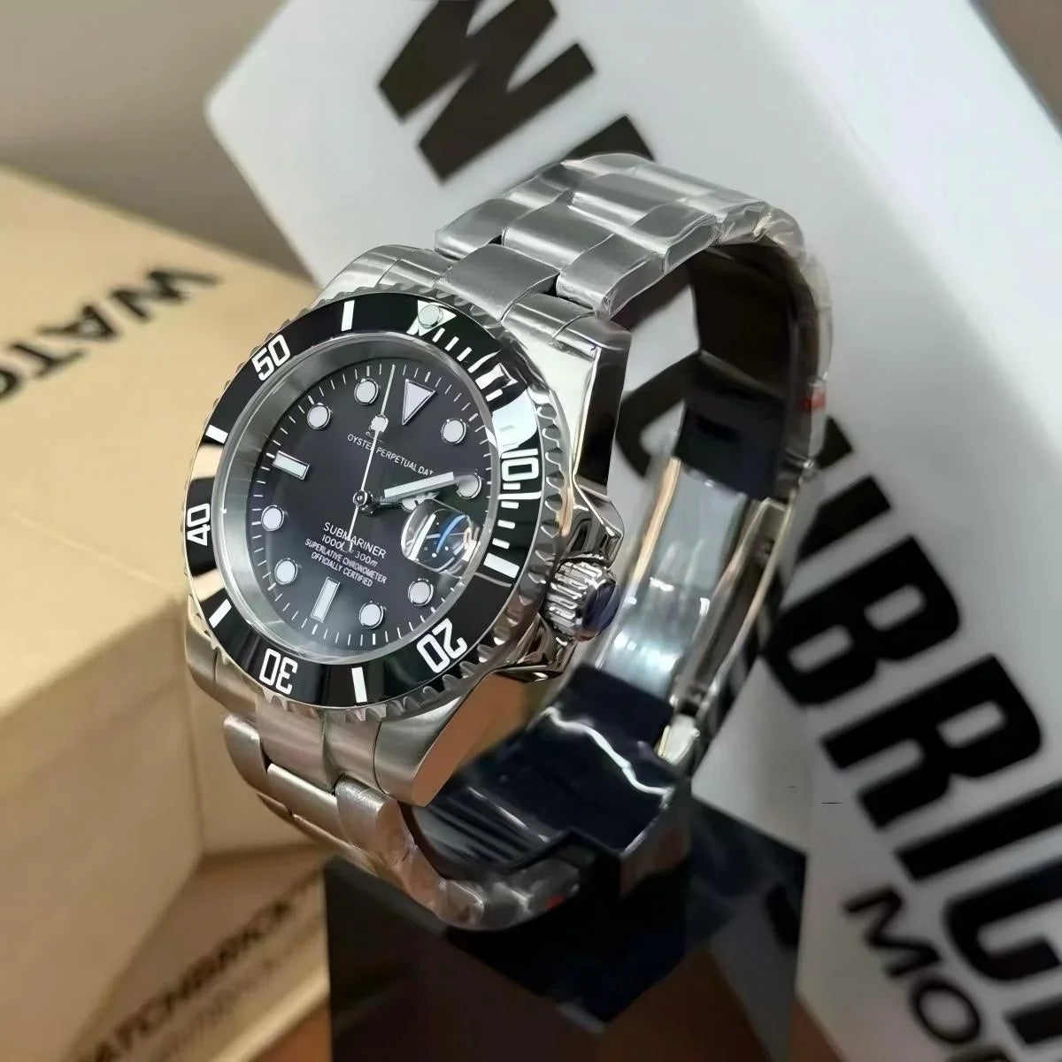 Stainless steel diver style watch with black bezel and black dial on display stand