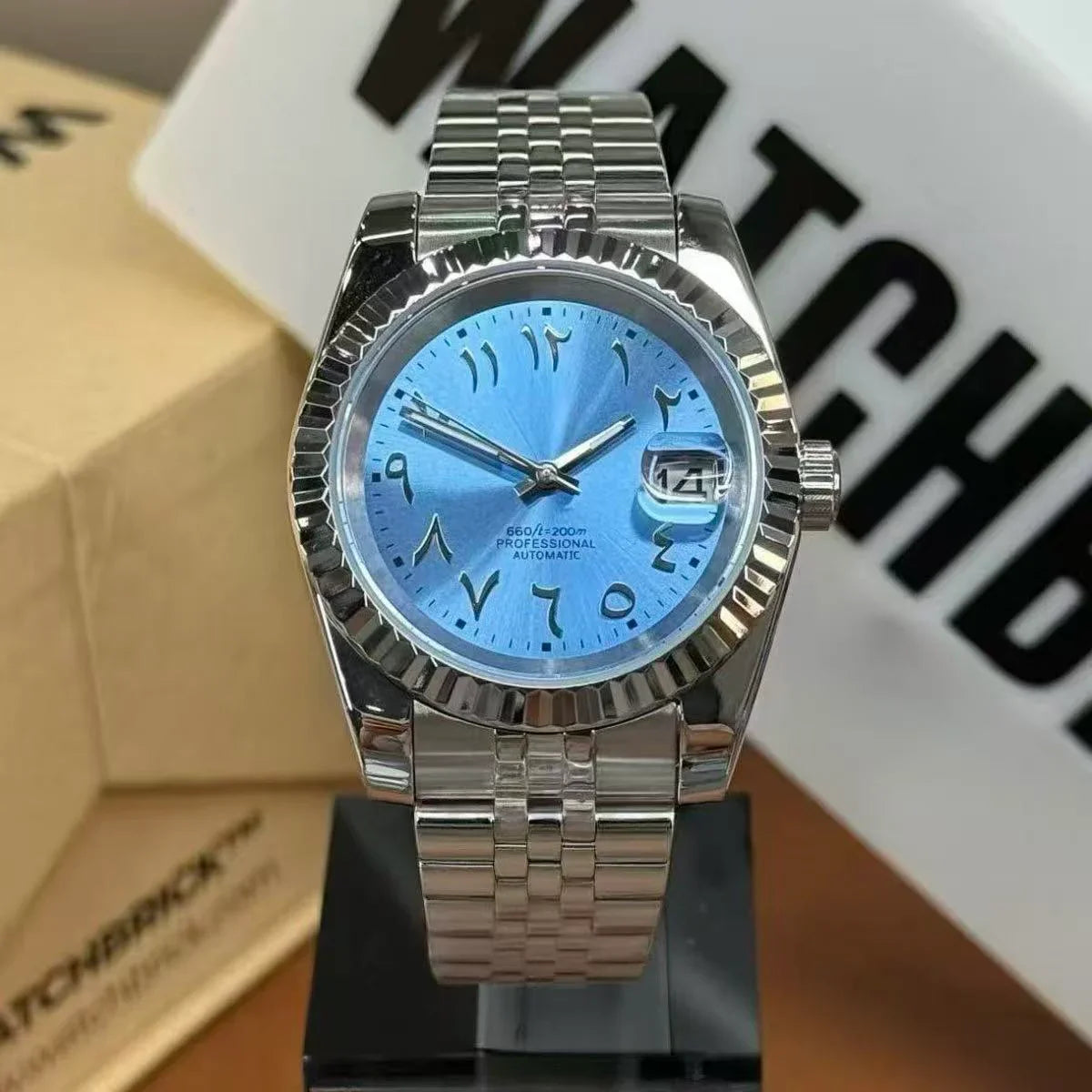 Stainless steel automatic watch with blue dial, Arabic numerals, and date window on stand
