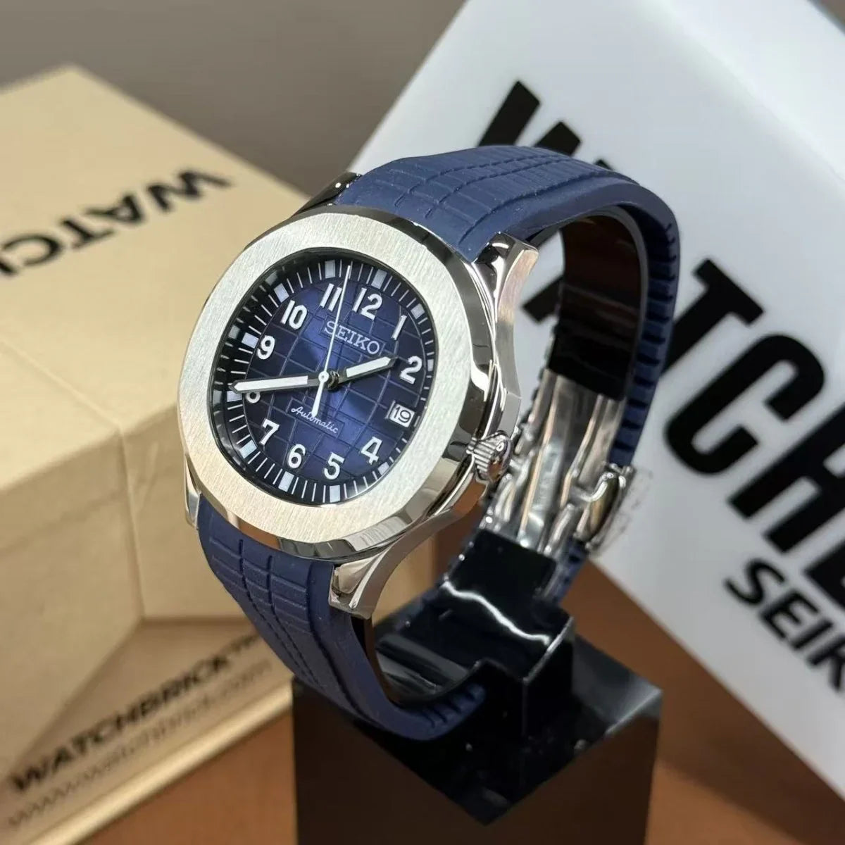 Blue and black Seiko mod watch with grid dial, silver bezel, and blue silicone strap