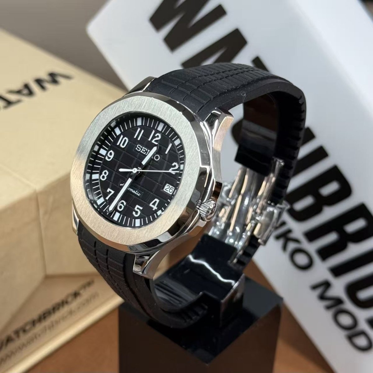 Black Seiko mod watch with silver bezel, black rubber strap, and date display on stand