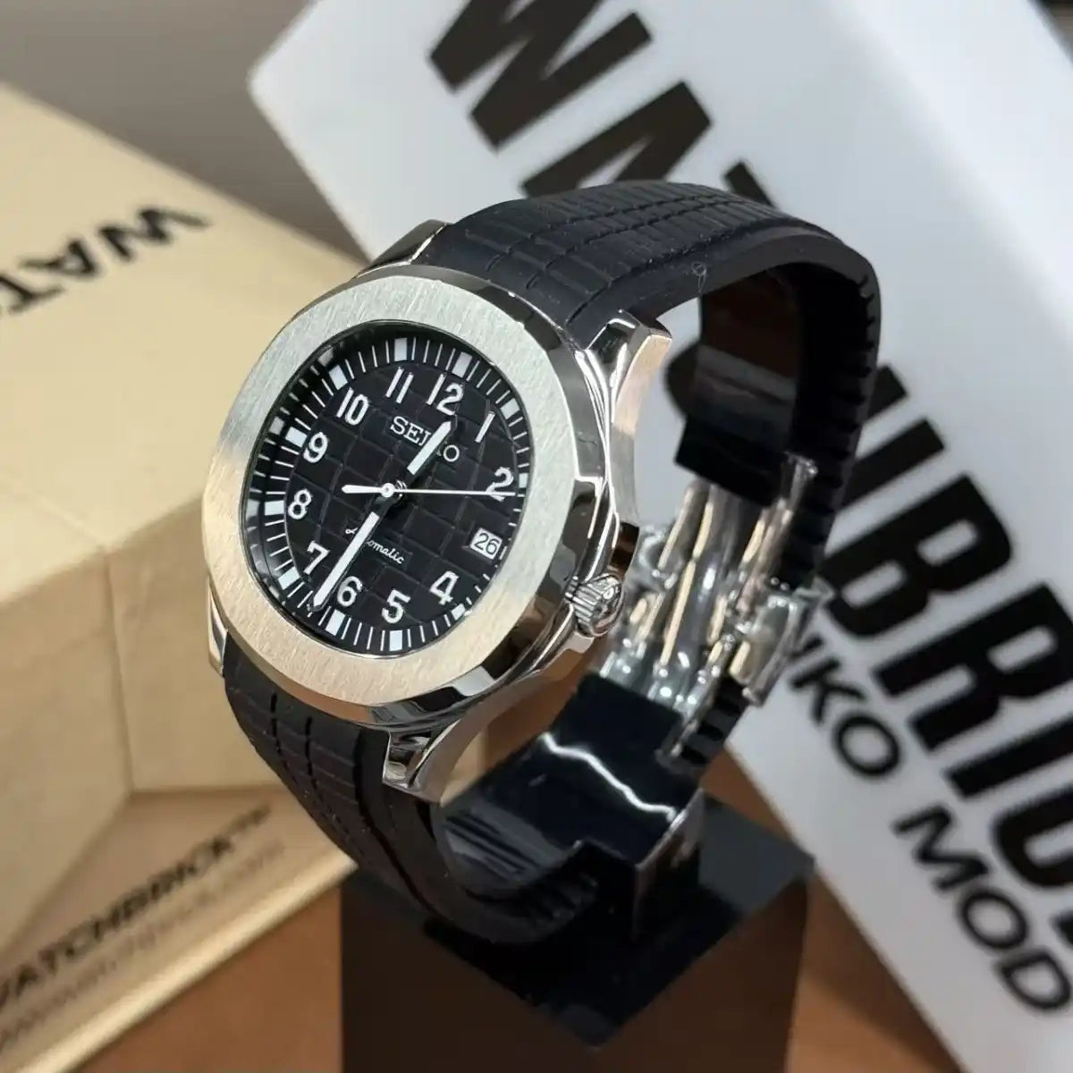Black Seiko mod watch with silver bezel, black rubber strap, and date display on stand