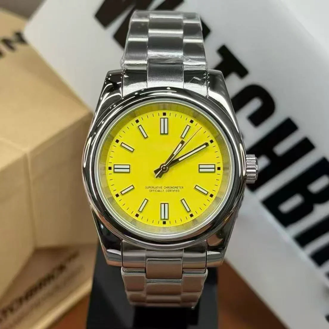 Stainless steel wristwatch with bright yellow dial and luminous markers, close-up view