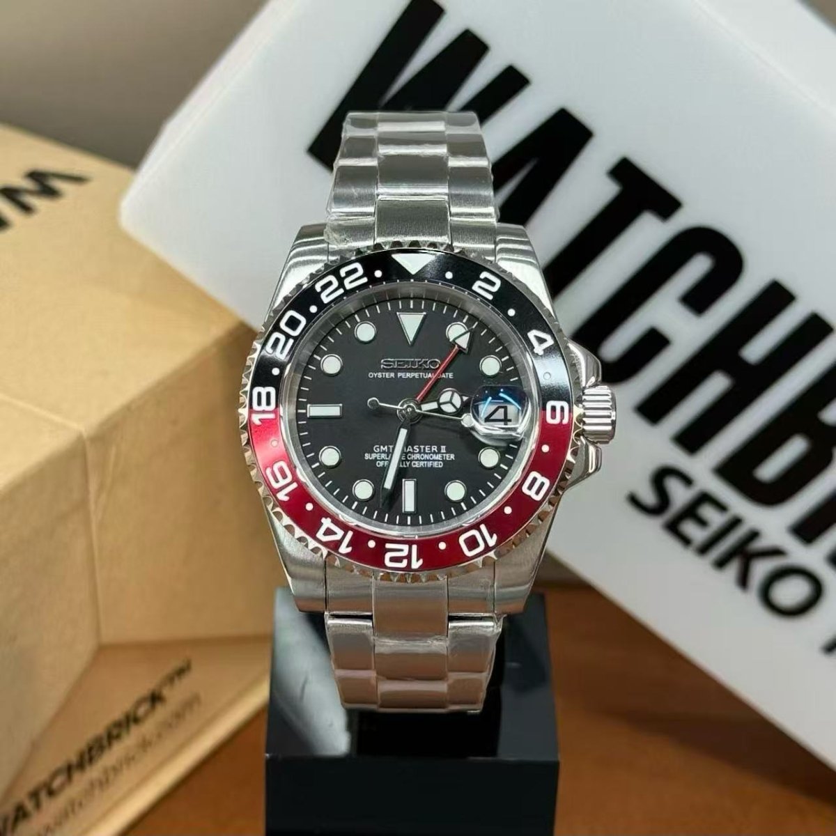 Seiko modded GMT watch with black and red dual time bezel and stainless steel bracelet