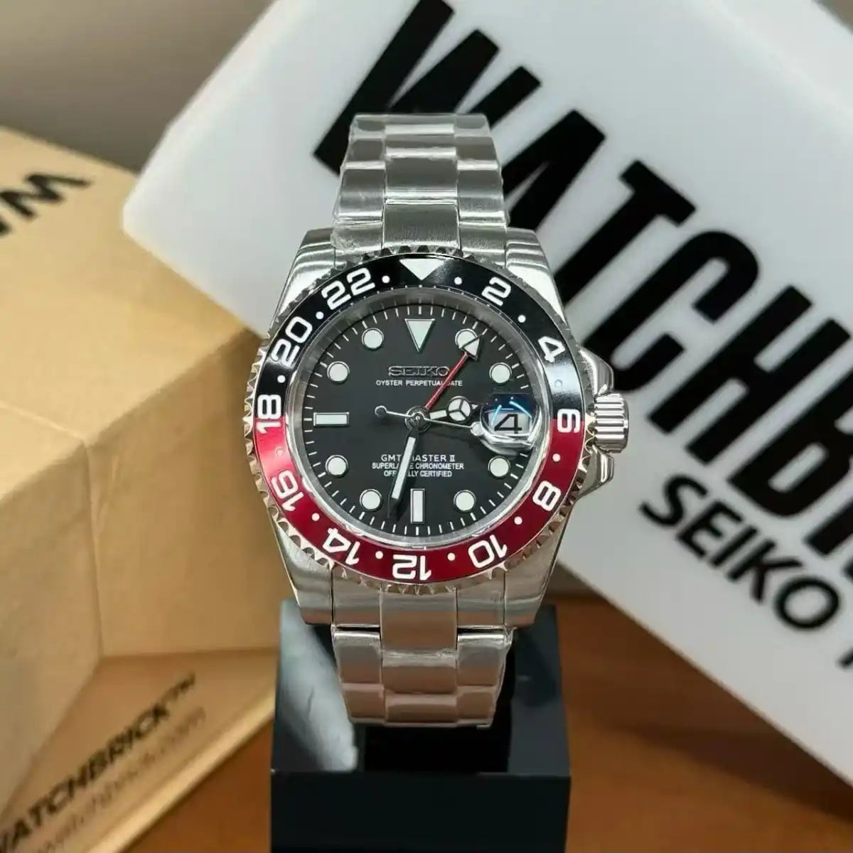 Seiko modded GMT watch with black and red dual time bezel and stainless steel bracelet