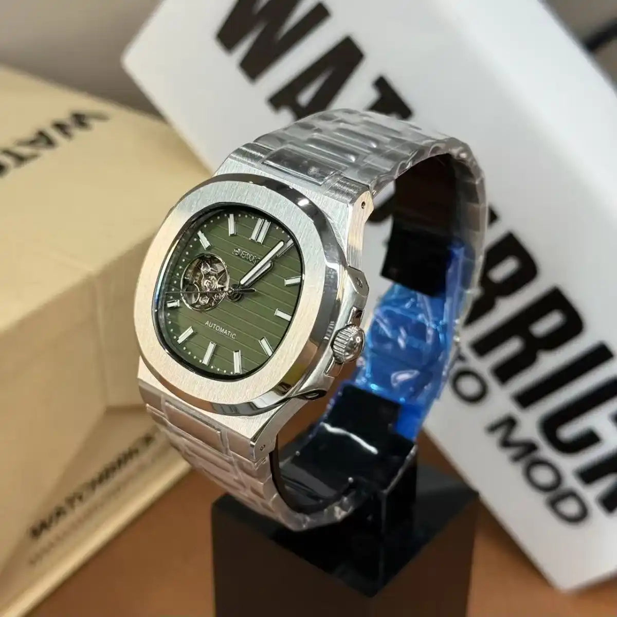 Stainless steel automatic watch with green open-heart dial and silver link bracelet