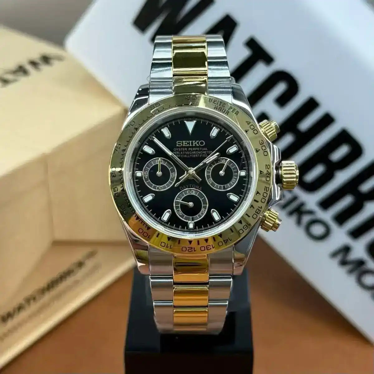 Two-tone Seiko mod chronograph watch with black dial and gold steel bracelet on display