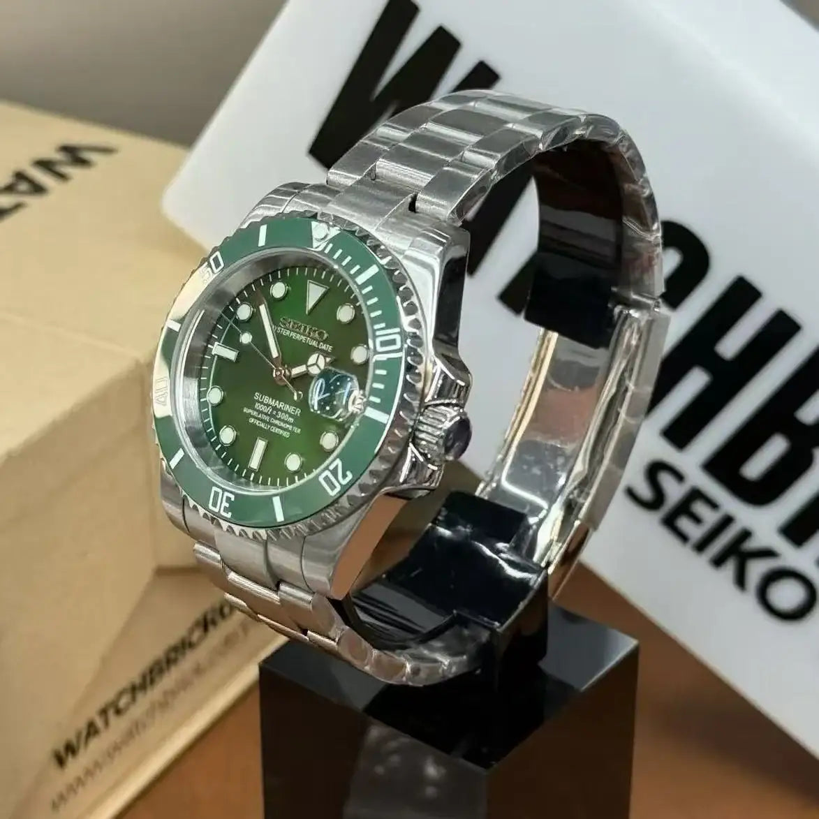 Stainless steel Seiko mod watch with green dial and bezel, NH35 automatic movement, on display stand