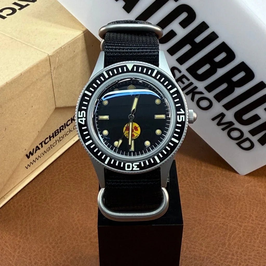 Custom Seiko mod watch with black NATO strap, black dial, and unique logo, on display