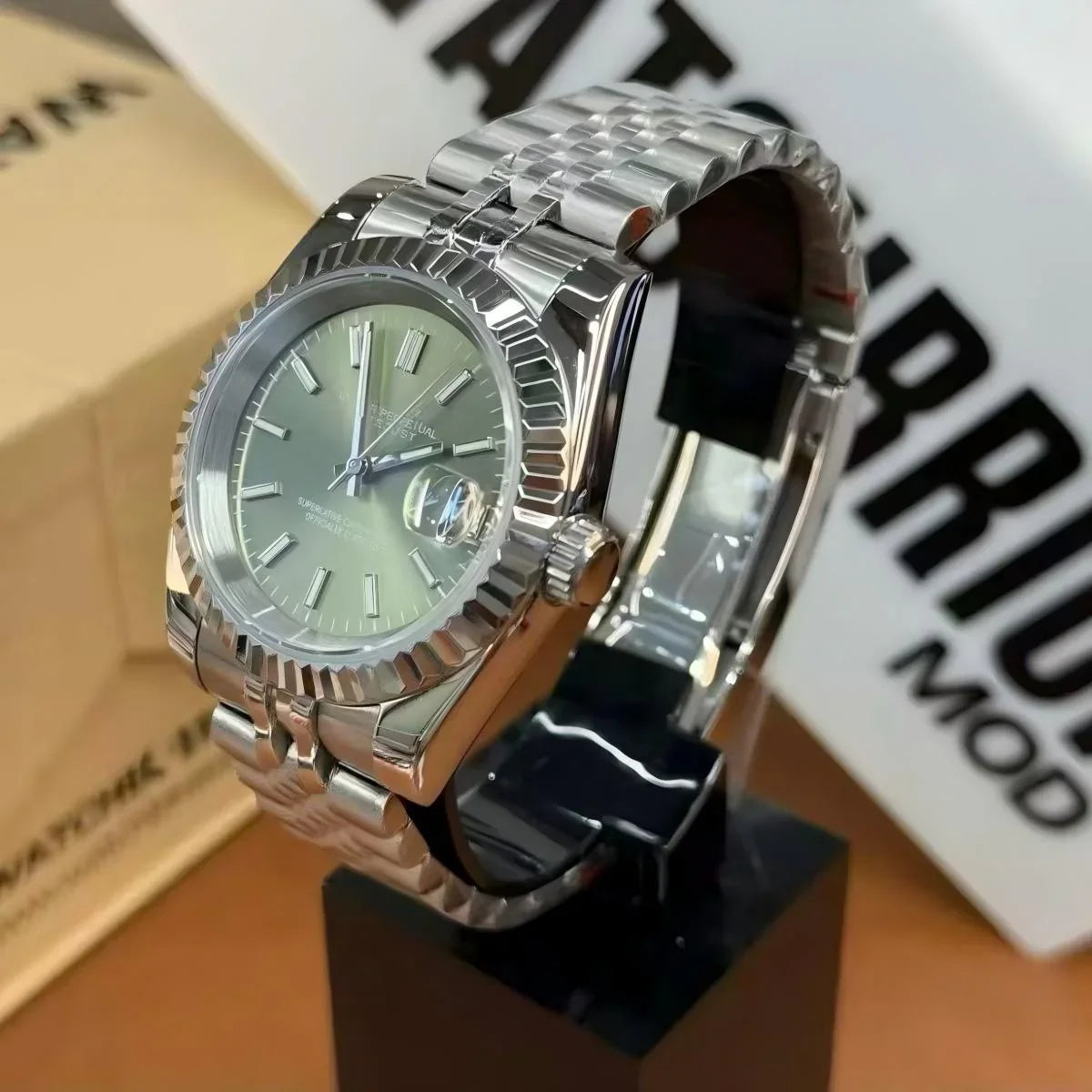 Stainless steel Seiko mod watch with fluted bezel and date display on metal bracelet