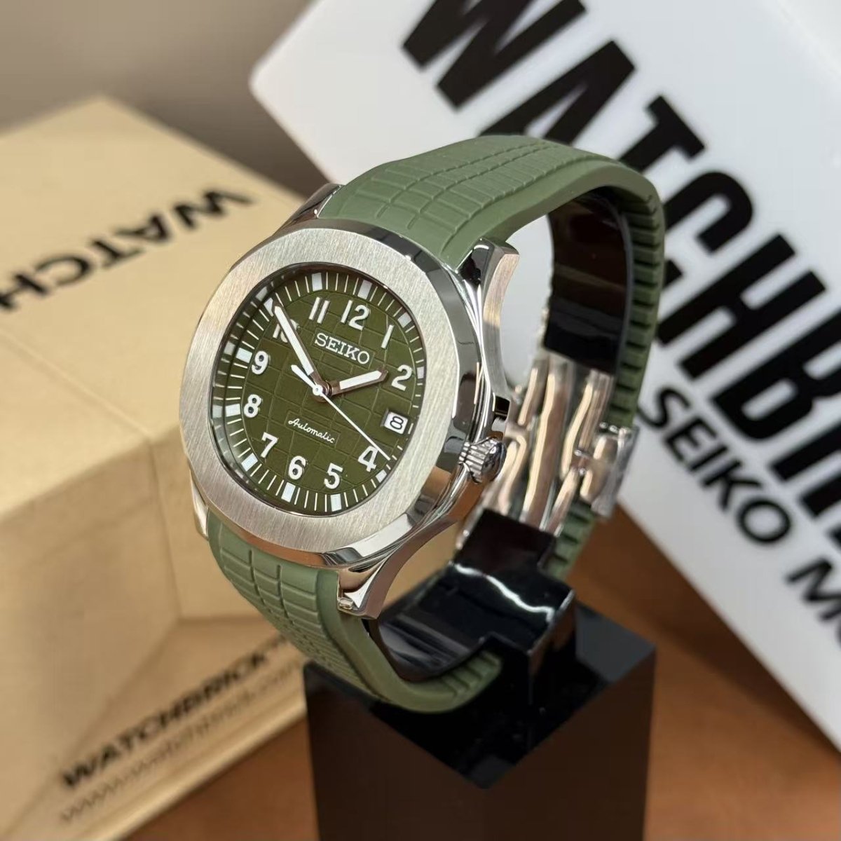 Seiko mod watch with green jungle dial and matching green rubber strap on display stand