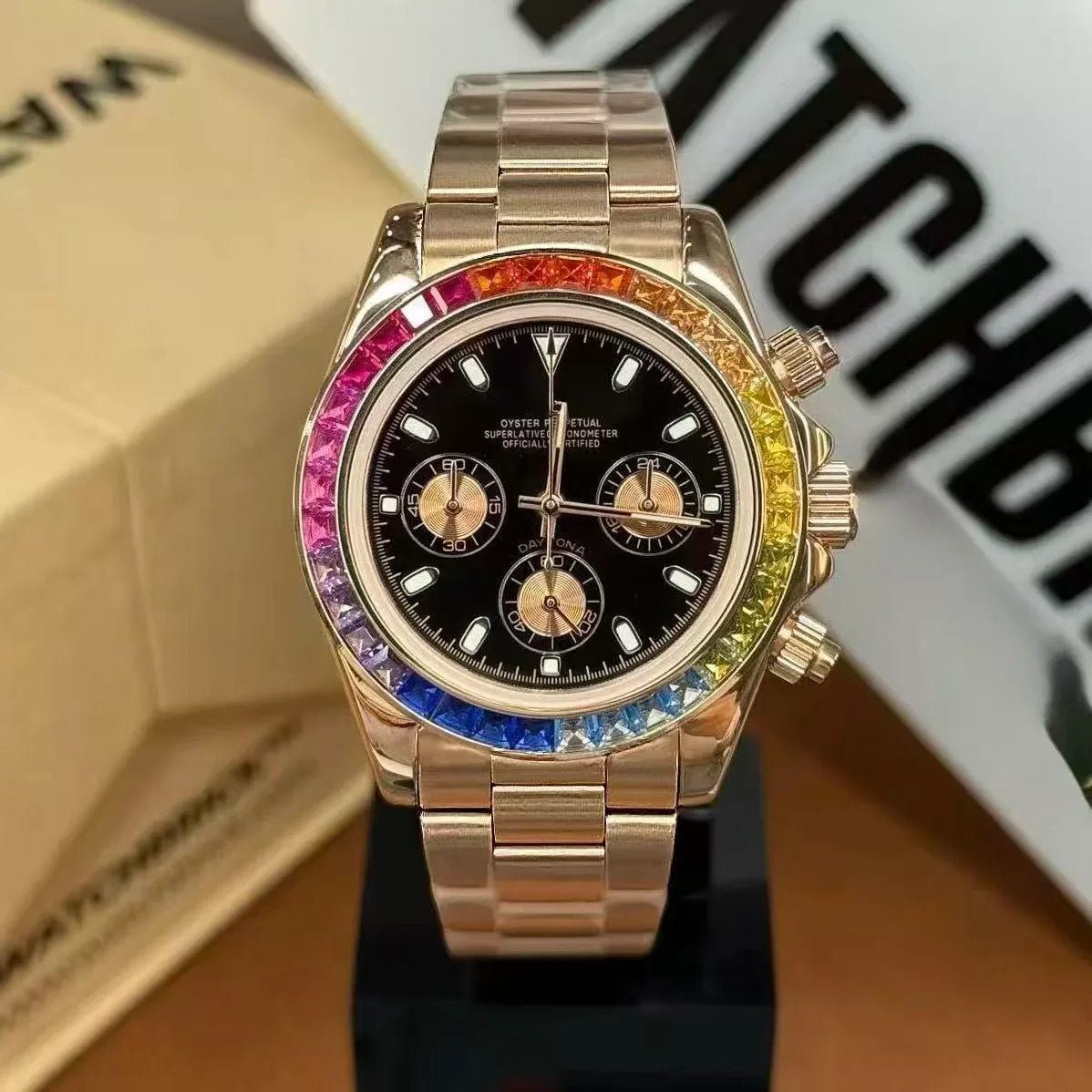 Luxury chronograph watch with rainbow sapphire bezel, black dial, and gold metal bracelet