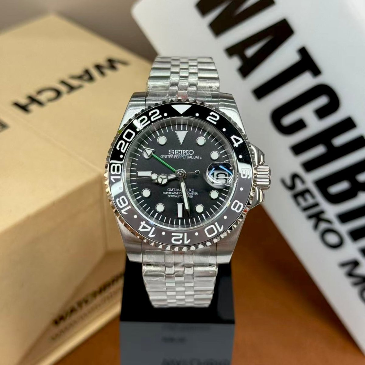 Seiko mod GMT watch with black bezel, sapphire crystal, and stainless steel bracelet