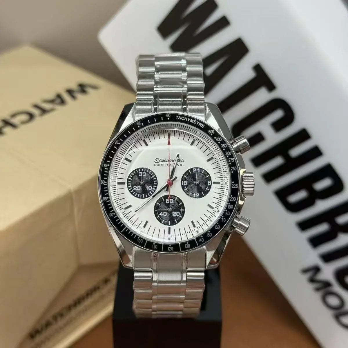 Stainless steel chronograph watch with white dial, black subdials, and tachymeter bezel