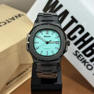 Seiko automatic mod watch with Tiffany blue dial, black case, and date window display.