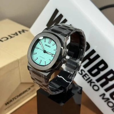 Seiko mod watch with tiffany blue dial, black case, and stainless steel bracelet