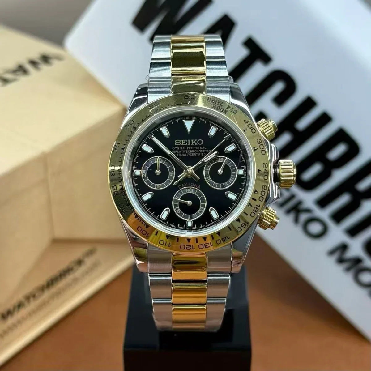 Two-tone Seiko mod chronograph watch with black dial and gold steel bracelet on display