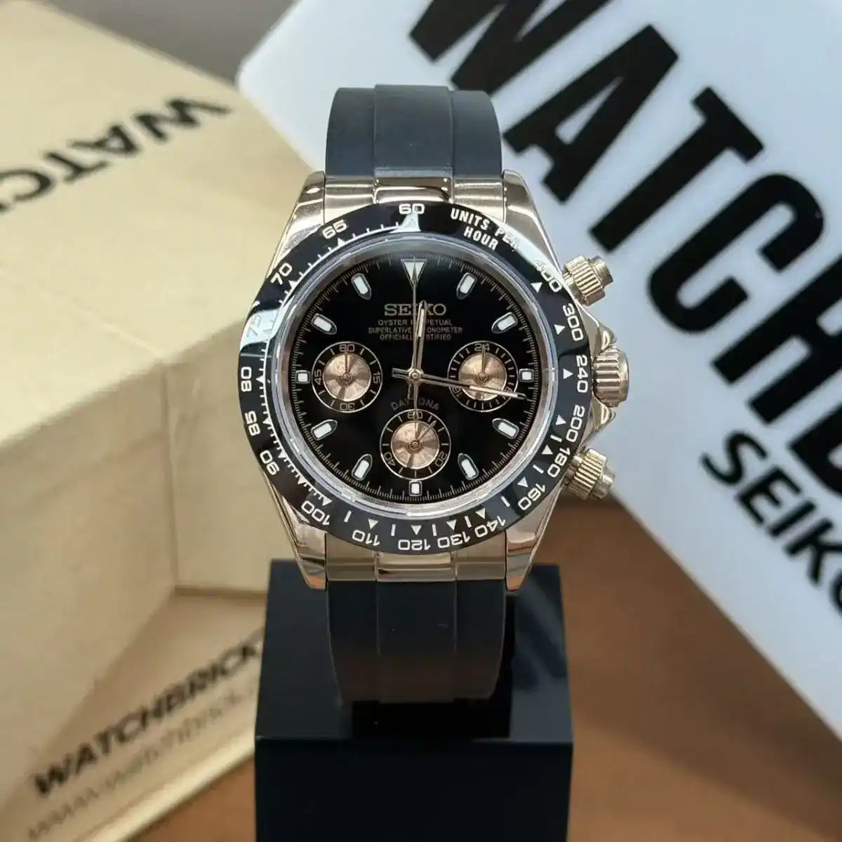 Rose gold Seiko mod watch with black dial, chronograph subdials, and black rubber strap